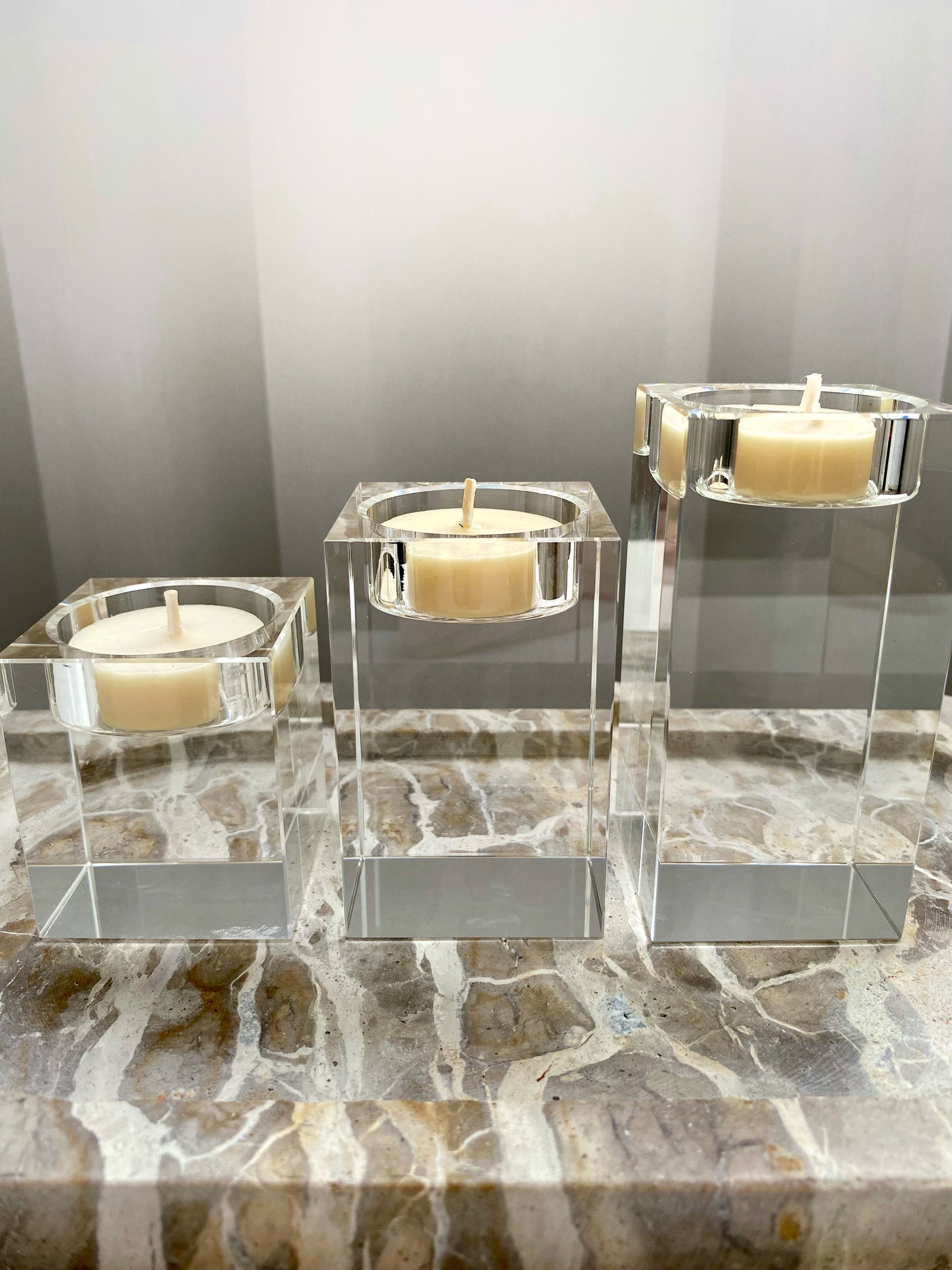 Three clear glass candle holders with candles on a marble surface.
Decorative candle holders set.
Crystal tea light candle holders, set of 3, house decor ideas, gift ideas.
Elegant, minimalist and modern candle holders.
Timeless house decor. Coffee table styling, dinning setting styling. 
Luna Deco