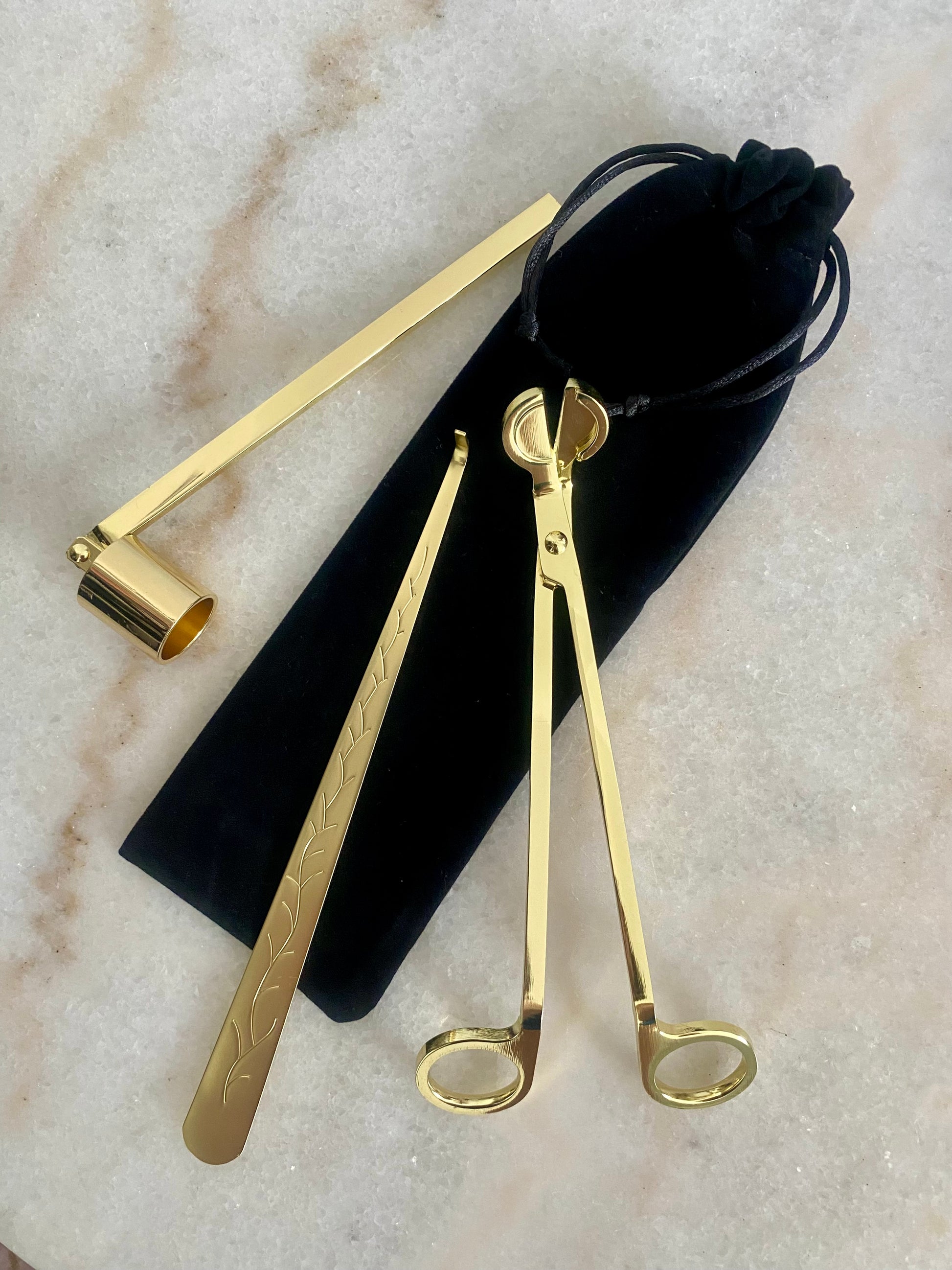 Set of gold candle care set - wick trimmer, candle snuffer and dipper on a marble surface with a black velvet pouch.
Candle essentials, candle accessories, 
must-have for every true candle lover - designed to enhance the longevity, beauty and ritual pf your candle. 
Luna Deco