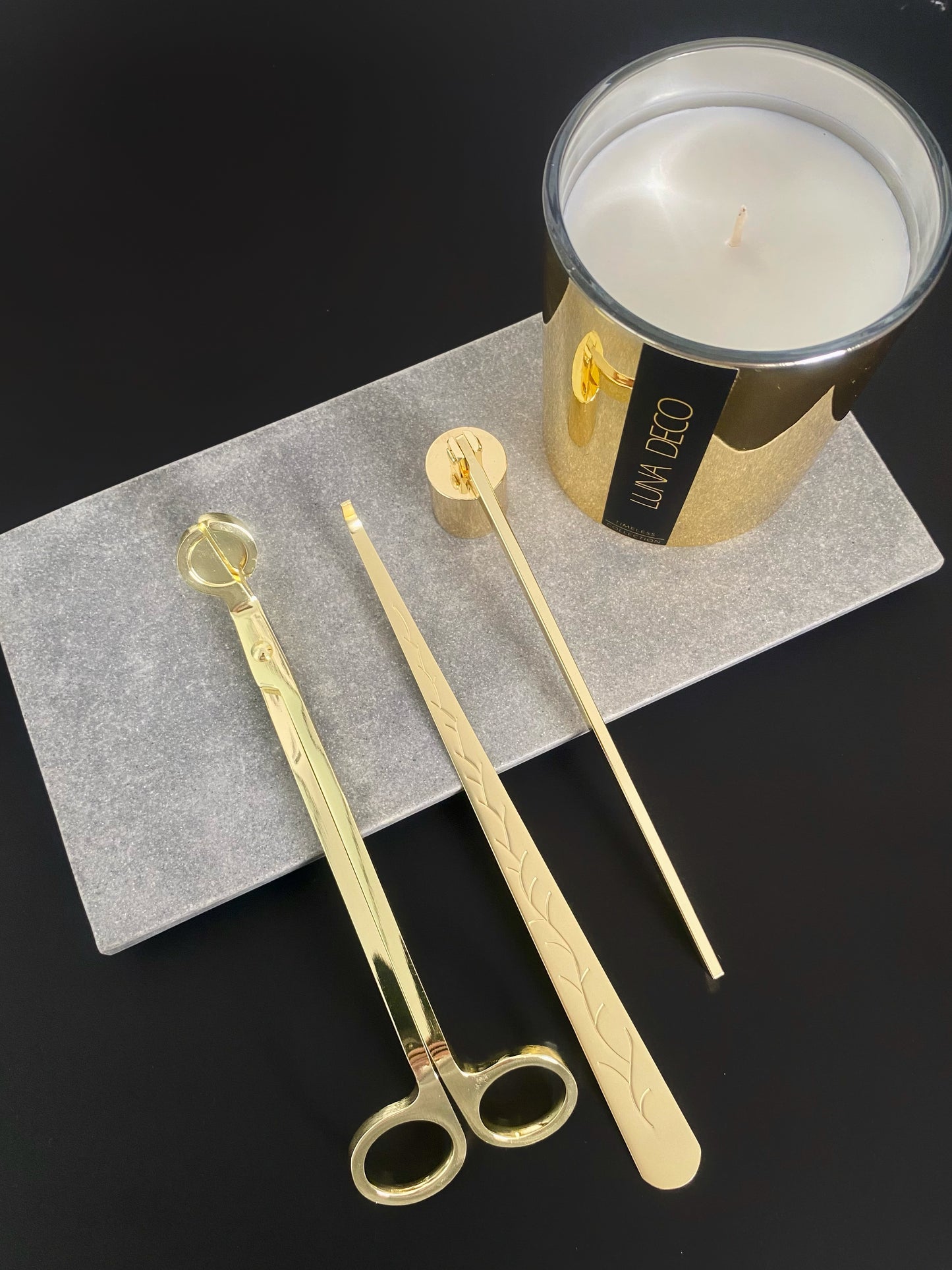 Gold candle snuffers, wick trimmer and dipper on a gray surface with a gold candle labeled 'Luna Deco' in the background.
Candle essentials, candle accessories, 
must-have for every true candle lover - designed to enhance the longevity, beauty and ritual pf your candle. 
Luna Deco