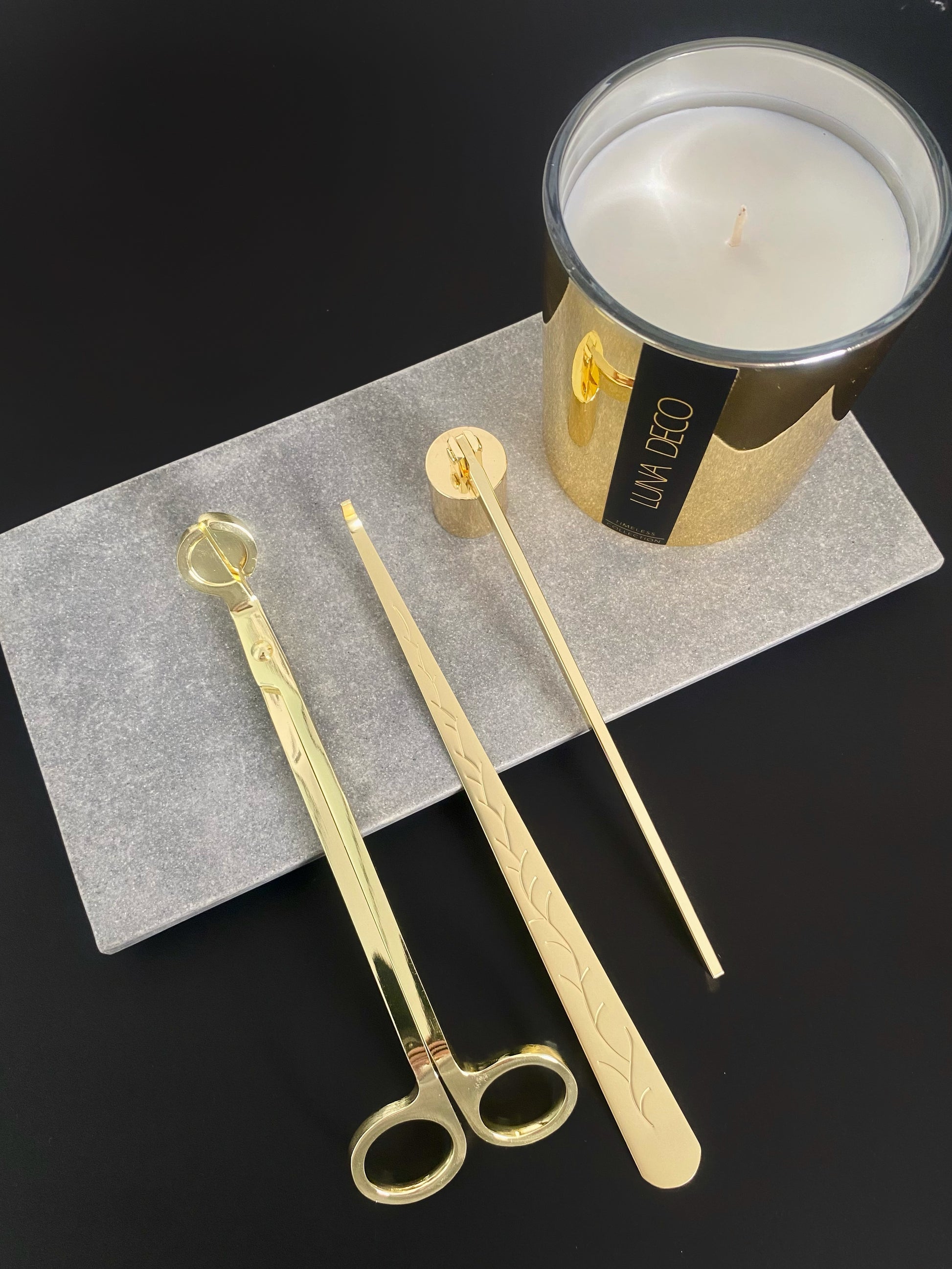 Gold candle snuffers, wick trimmer and dipper on a gray surface with a gold candle labeled 'Luna Deco' in the background.
Candle essentials, candle accessories, 
must-have for every true candle lover - designed to enhance the longevity, beauty and ritual pf your candle. 
Luna Deco