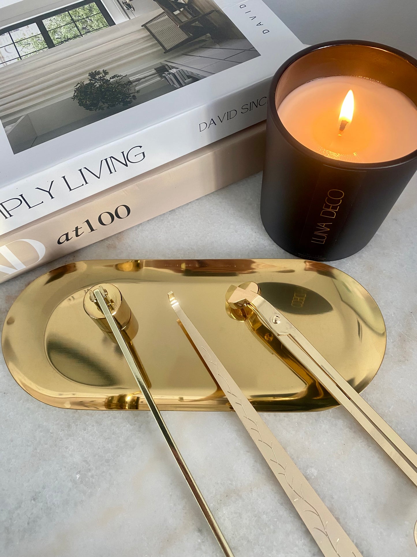 Gold tray with candles and a book on a light surface including candle care set - wick trimmer, candle snuffer and dipper. 
Candle essentials, candle accessories, 
must-have for every true candle lover - designed to enhance the longevity, beauty and ritual pf your candle. 
Luna Deco