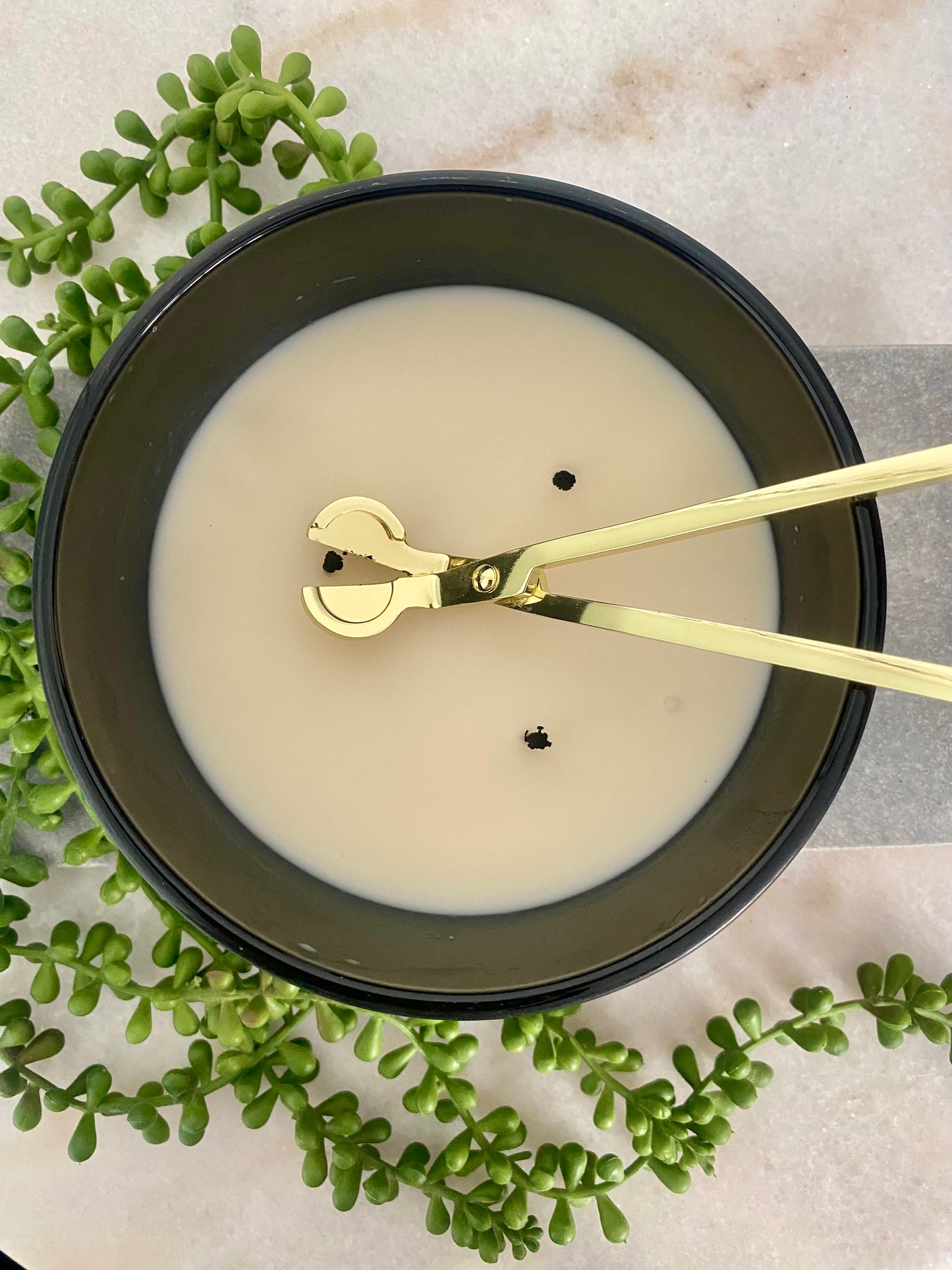 Candle with a 3 wicks and gold wick trimmer on marble surface with green leaves.
Candle essentials, candle accessories, 
must-have for every true candle lover - designed to enhance the longevity, beauty and ritual pf your candle. 
Luna Deco