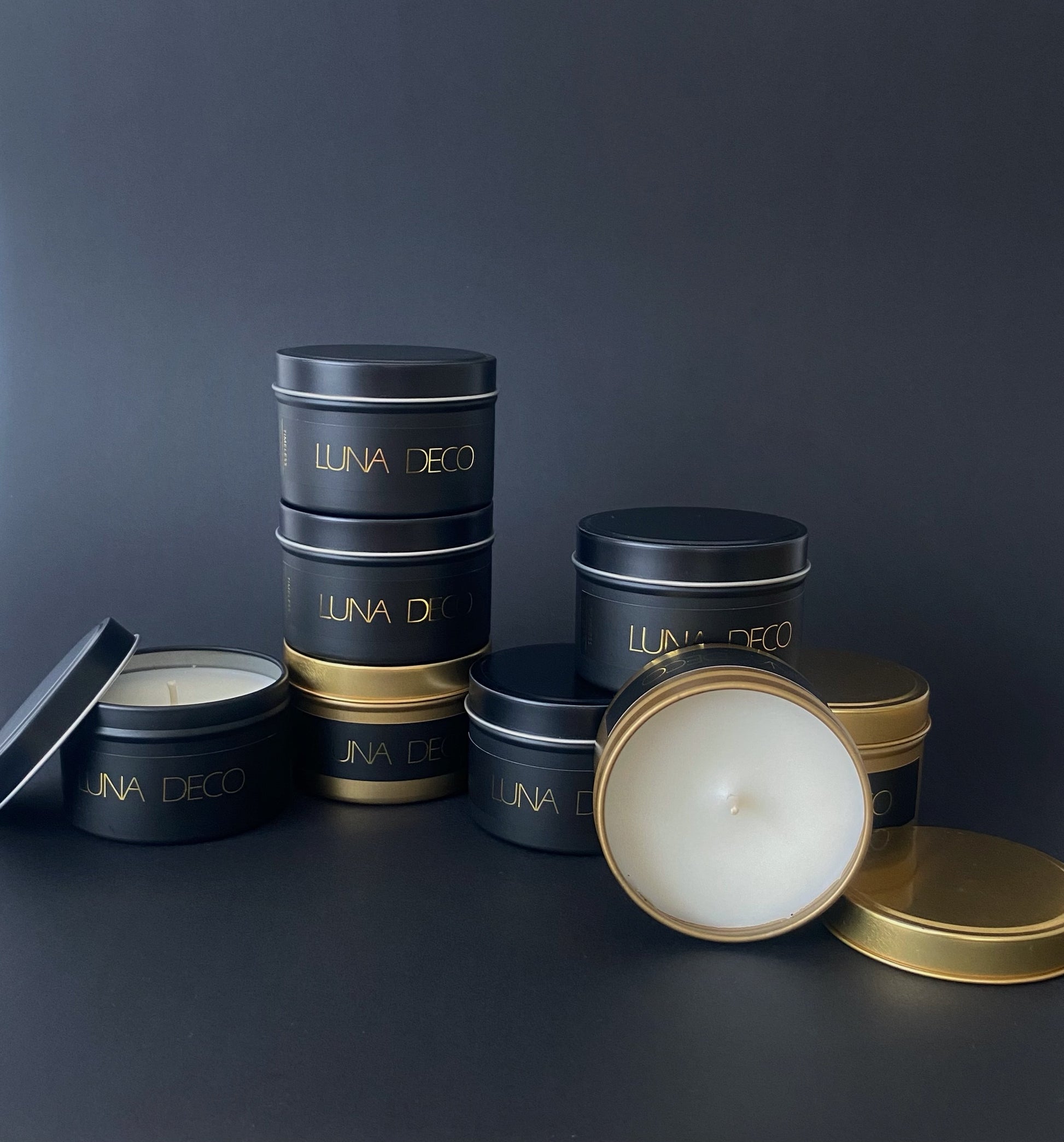 LUNA DECO travel tin candles on a dark background.
Matte gold and black travel tin candles,  perfect for travel, small spaces or thoughtful gifting.
Minimalist, timeless, elegant design, artisan-made candles. 
Luna Deco. 